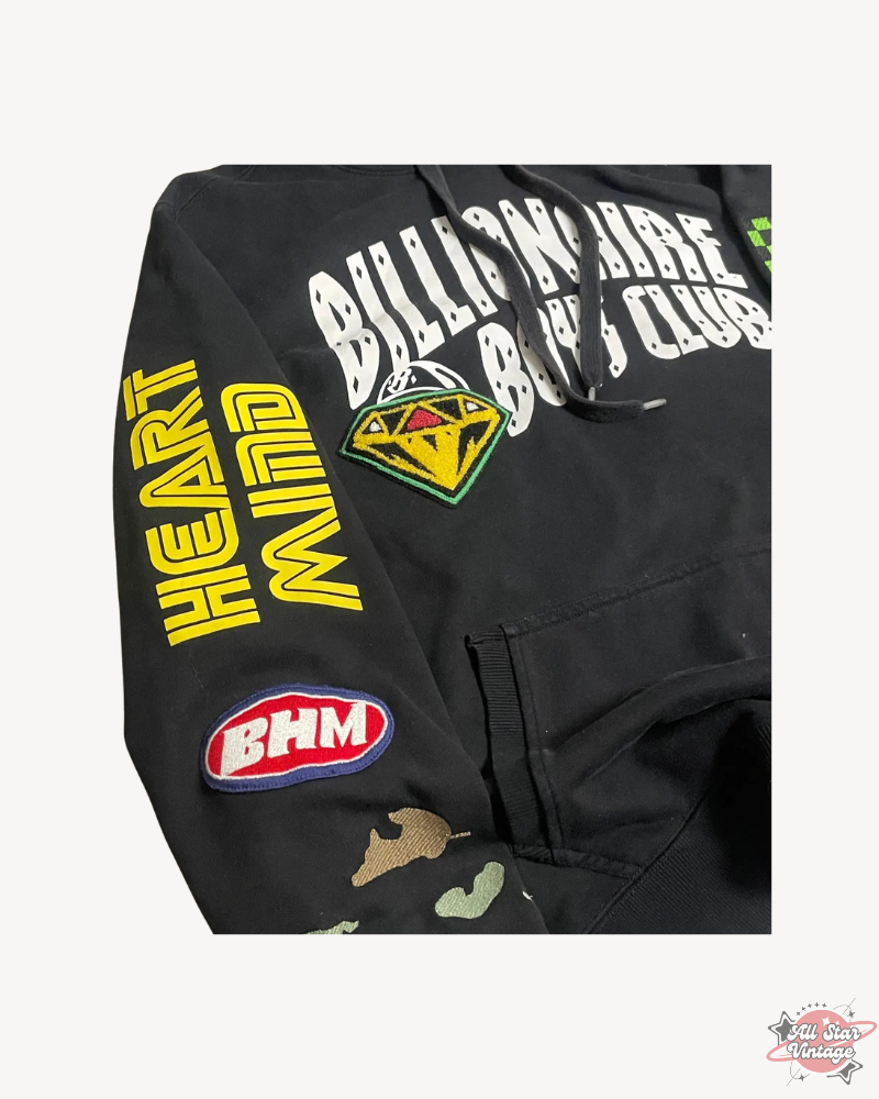 Close-up of the Billionaire Boys Club Factory Racing Team Hoodie sleeve featuring Heart Mind text, camo detailing, and BHM patch