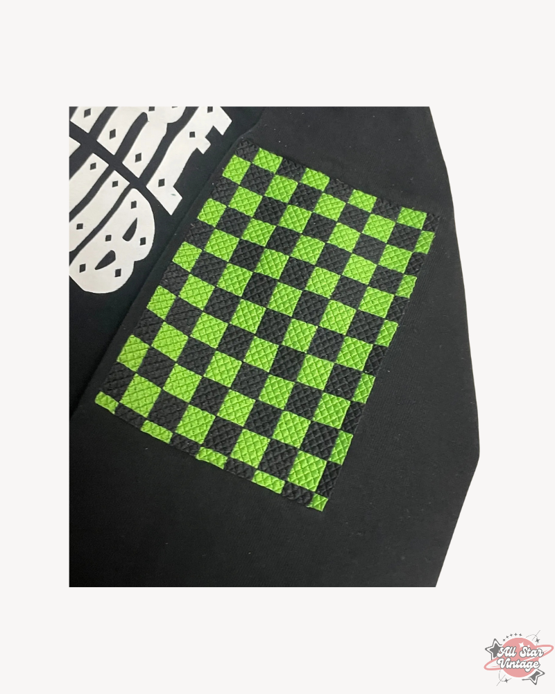 Close-up of the green and black checkered patch on the Billionaire Boys Club Factory Racing Team Hoodie sleeve