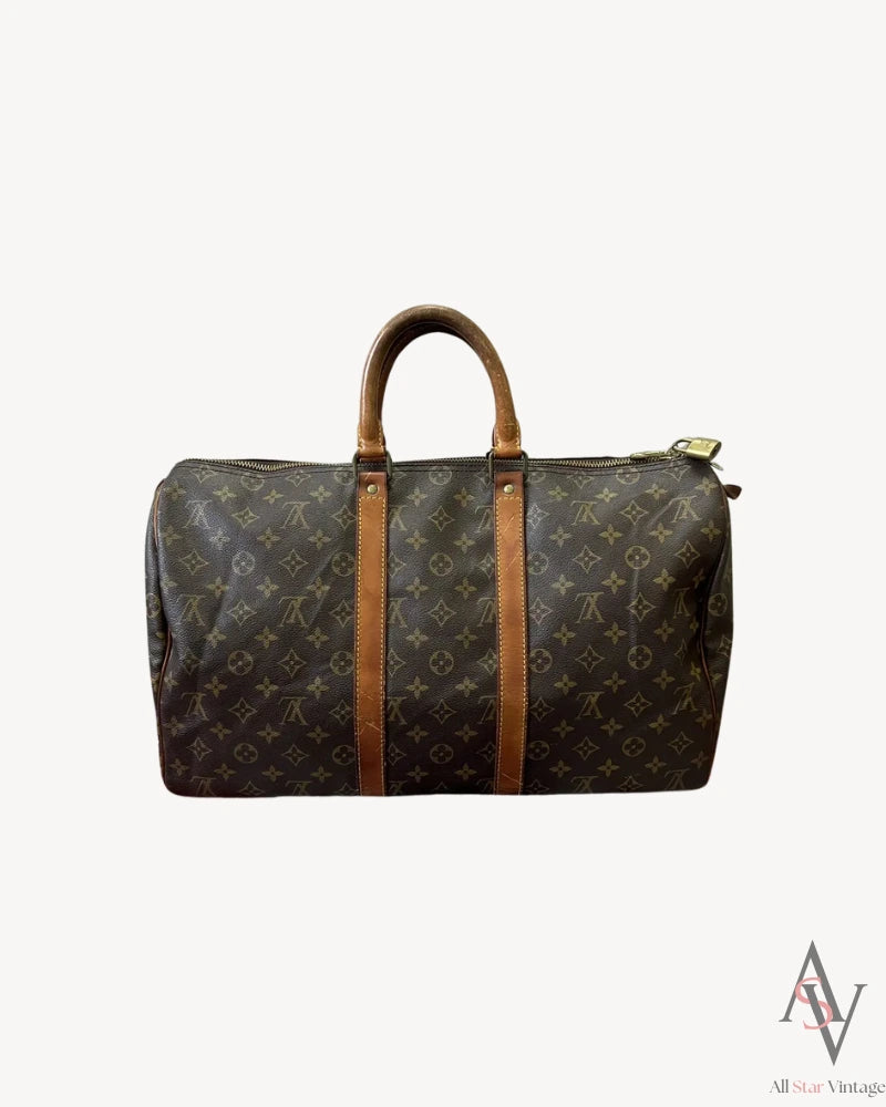 Front view of a vintage Louis Vuitton monogram duffle bag showcasing its iconic brown canvas with monogram pattern and leather straps