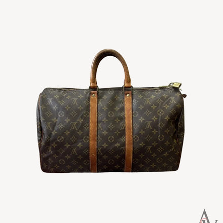 Front view of a vintage Louis Vuitton monogram duffle bag showcasing its iconic brown canvas with monogram pattern and leather straps