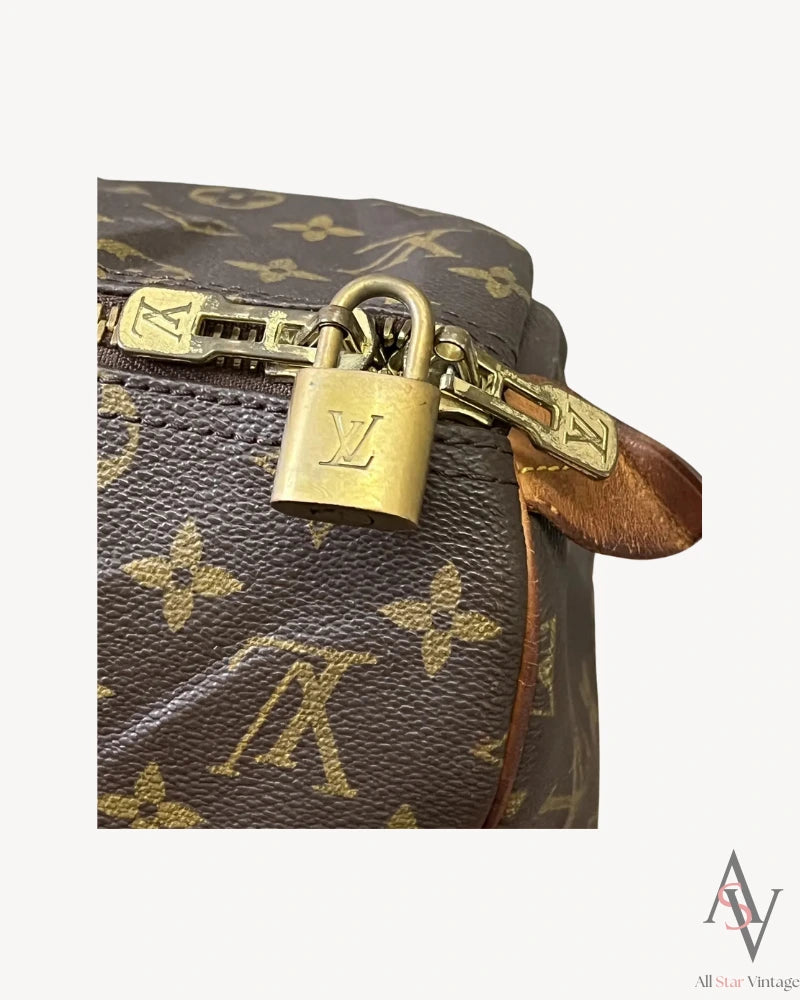 Alternate close-up of the Louis Vuitton brass padlock with LV engraving, adding to the bag’s vintage elegance