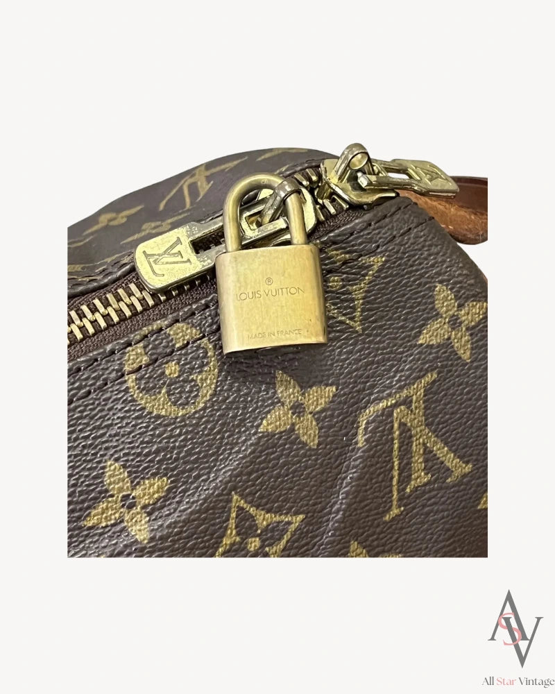 Close-up of the Louis Vuitton brass padlock attached to the zipper, engraved with “Made in France"