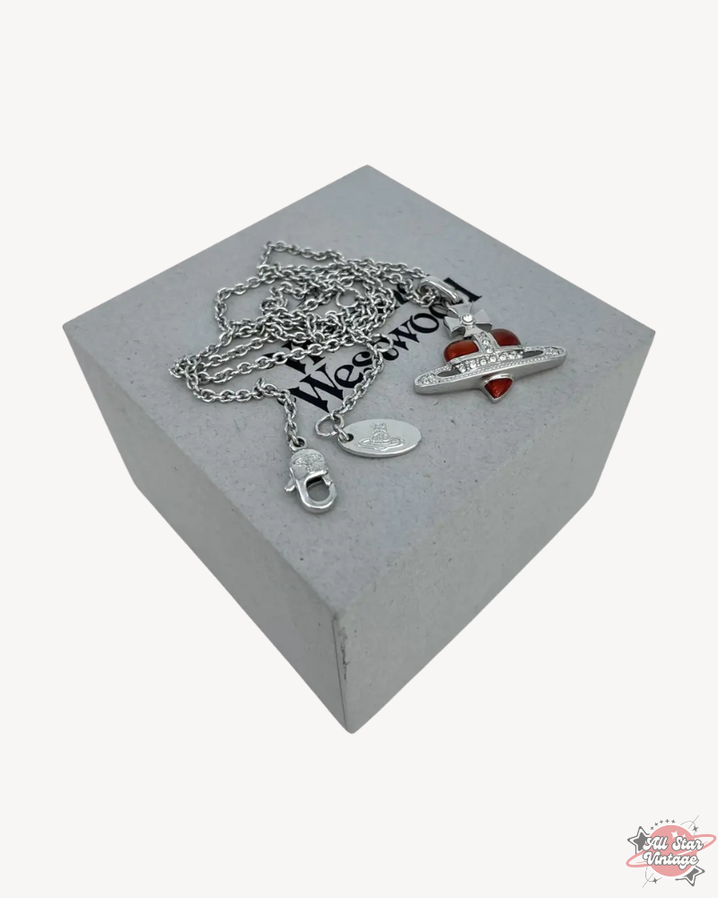 Vivienne Westwood Crystal Heart Orb Necklace with silver chain displayed on branded box. Luxury design featuring red heart and crystal accents, perfect for bold fashion statements.